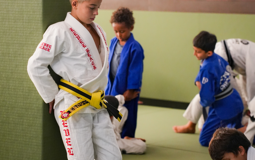 Young student in kids BJJ class at ARMA Clapham showing the children's belt system