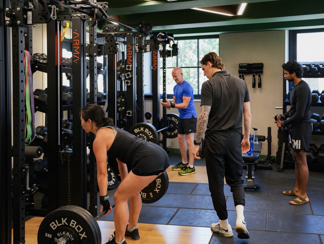 ARMA personal trainer coaching a small group strength session in the gym at ARMA Clapham