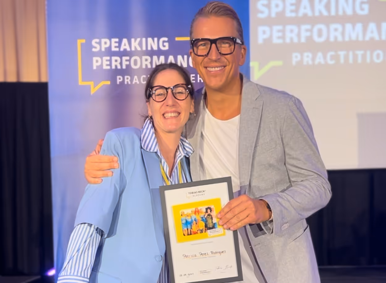 Übergabe von Abschlussbescheinigung von Speaking Perfomance Practinioner bei Tobias Beck Academy, Patricia und Tobias vor der Kamera halten die Abschlussbescheinigung.