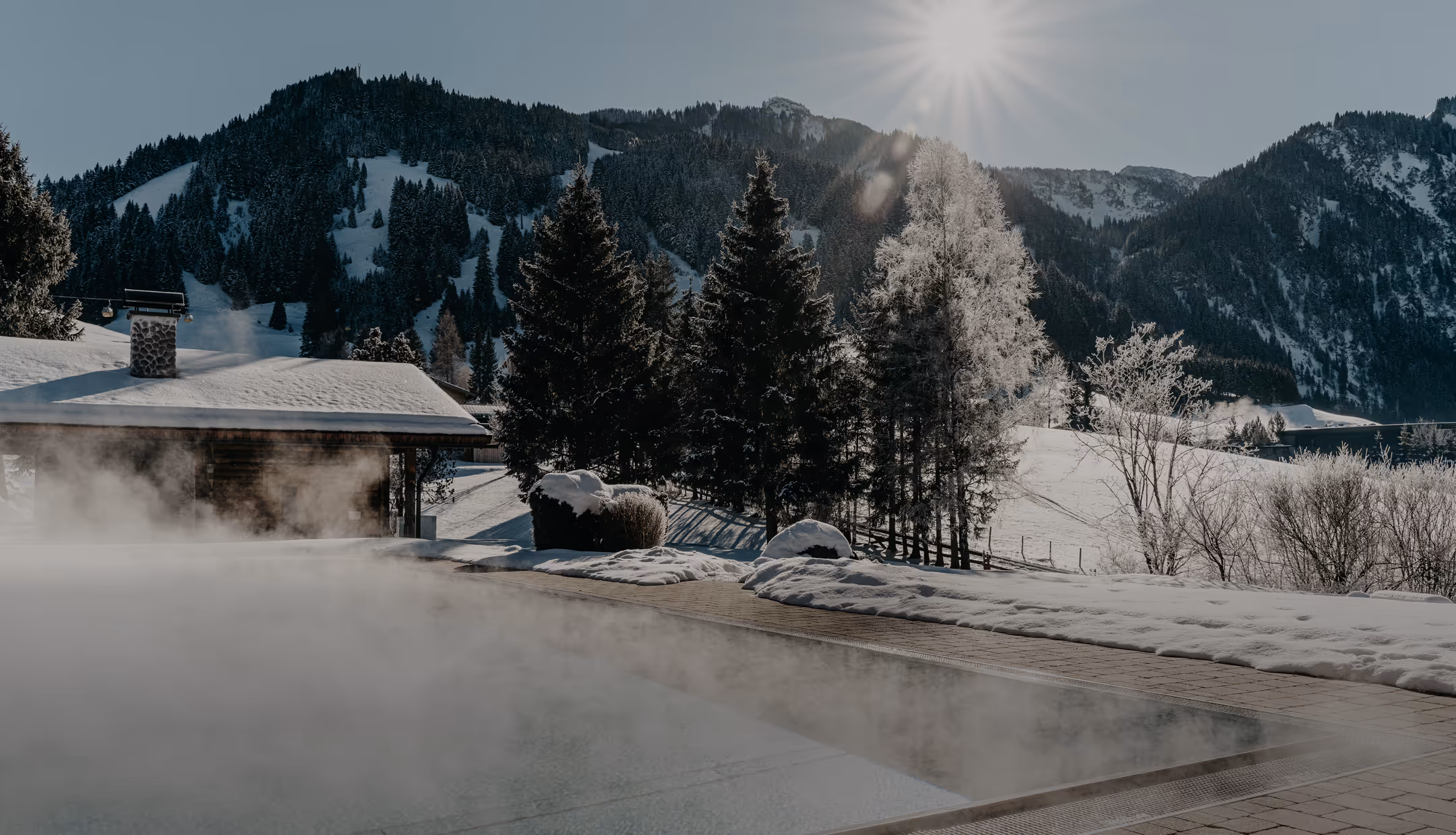 Beheizter Außenpool im Hotel Hohenfels Tirol – Entspannung mit Bergblick und Wintersonne.