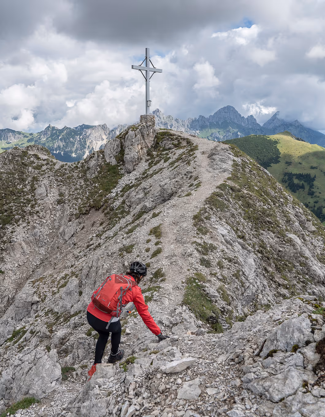 Wanderer am Gipfelkreuz im Tannheimer Tal – Ausblick über die Tiroler Alpen.