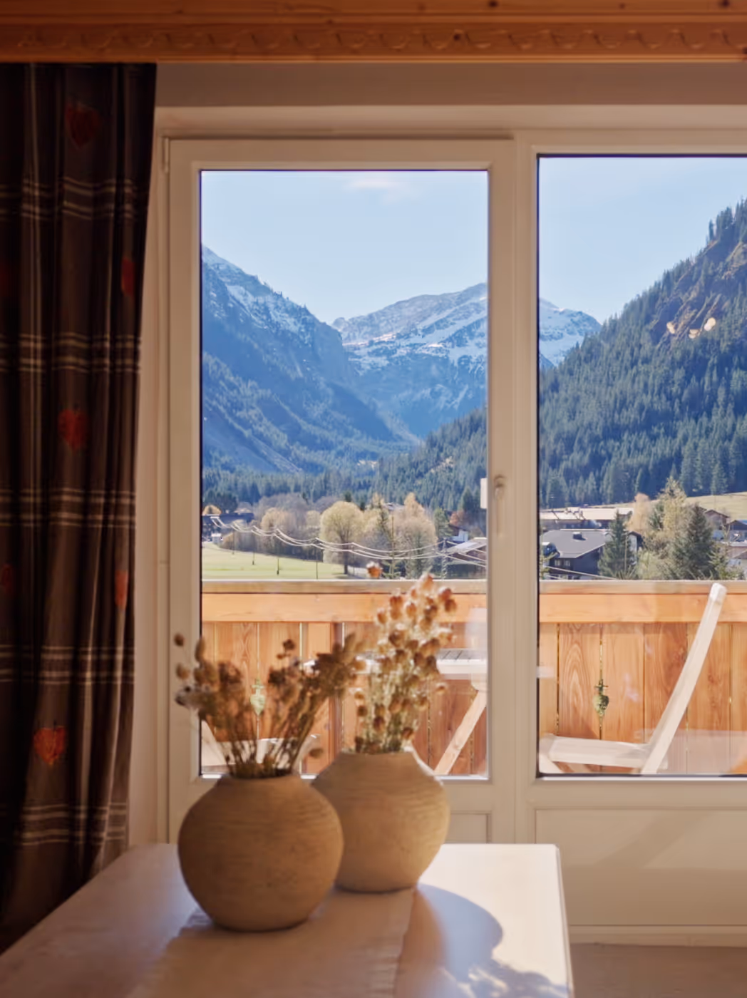 Blick vom Hotelzimmer des Hohenfels über das Tannheimer Tal mit Bergkulisse und Balkon.