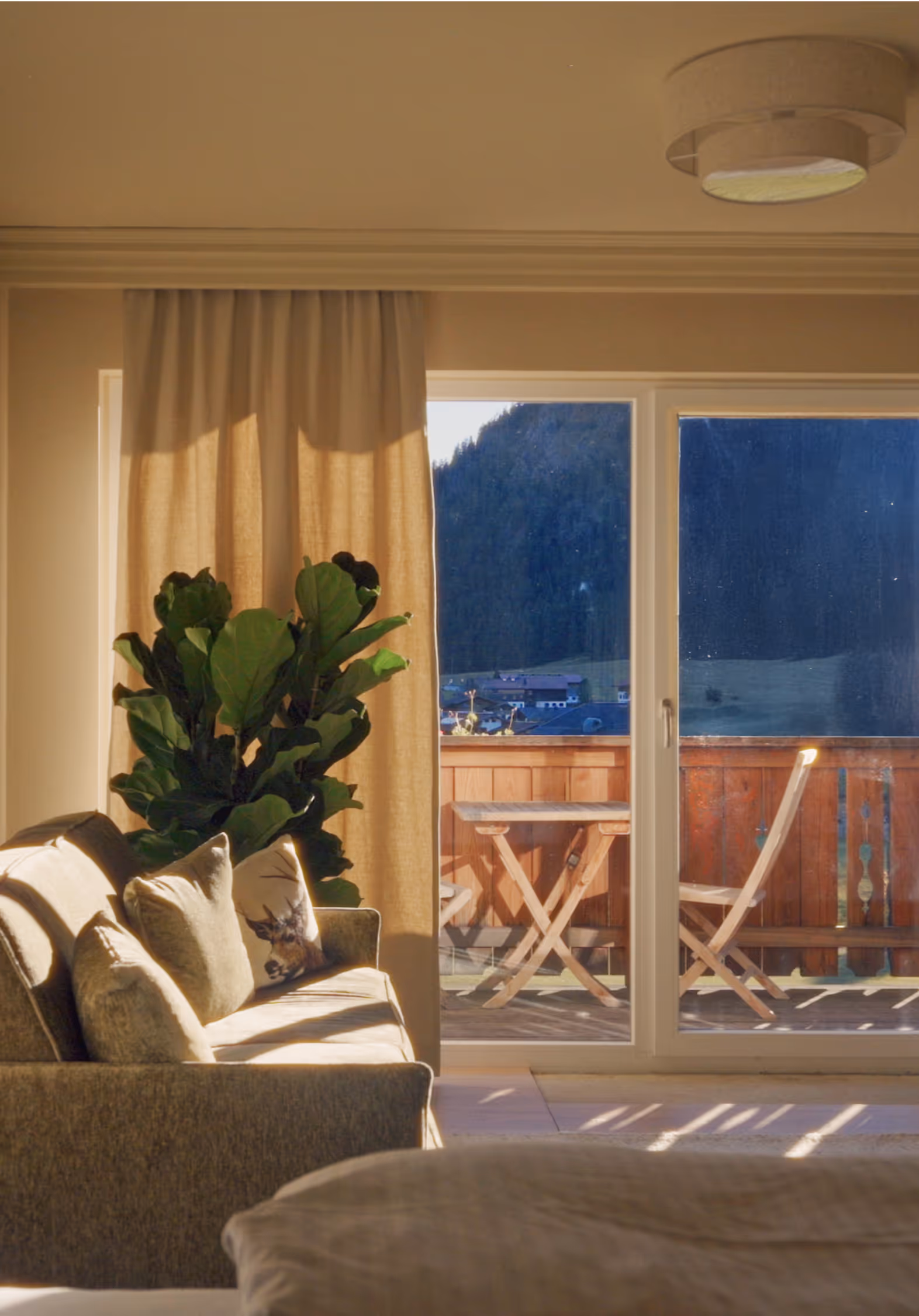 Heller Wohnraum der Junior Suite Vilsalpsee mit Balkon und Blick auf die Tiroler Alpenlandschaft.