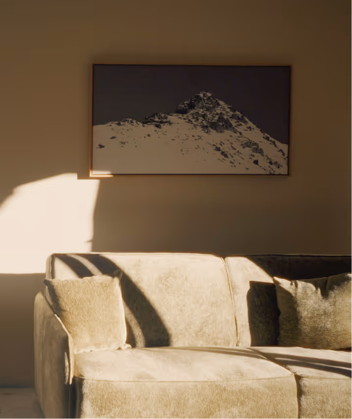 Sonnendurchflutetes Wohnzimmer der Suite Vilsalpsee mit edlem Samtsofa und Bergbild im Hotel Hohenfels Tirol.