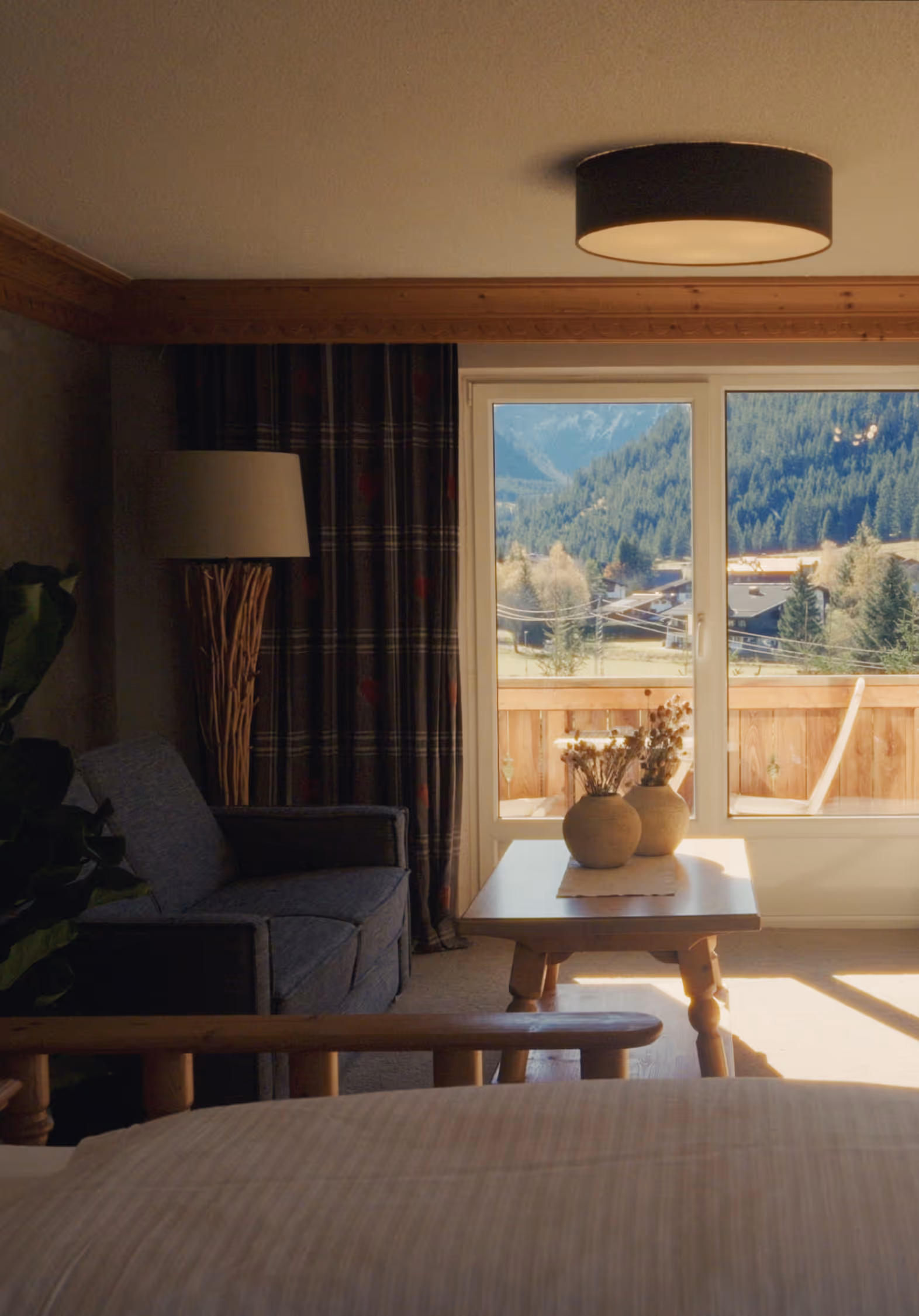 Suite Vergissmeinnicht mit Wohn- und Schlafbereich, gemütlichem Sofa und sonnigem Balkon mit Bergblick.