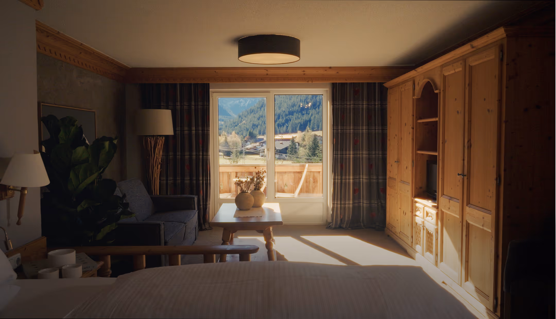 Suite Vergissmeinnicht mit Wohn- und Schlafbereich, gemütlichem Sofa und sonnigem Balkon mit Bergblick.