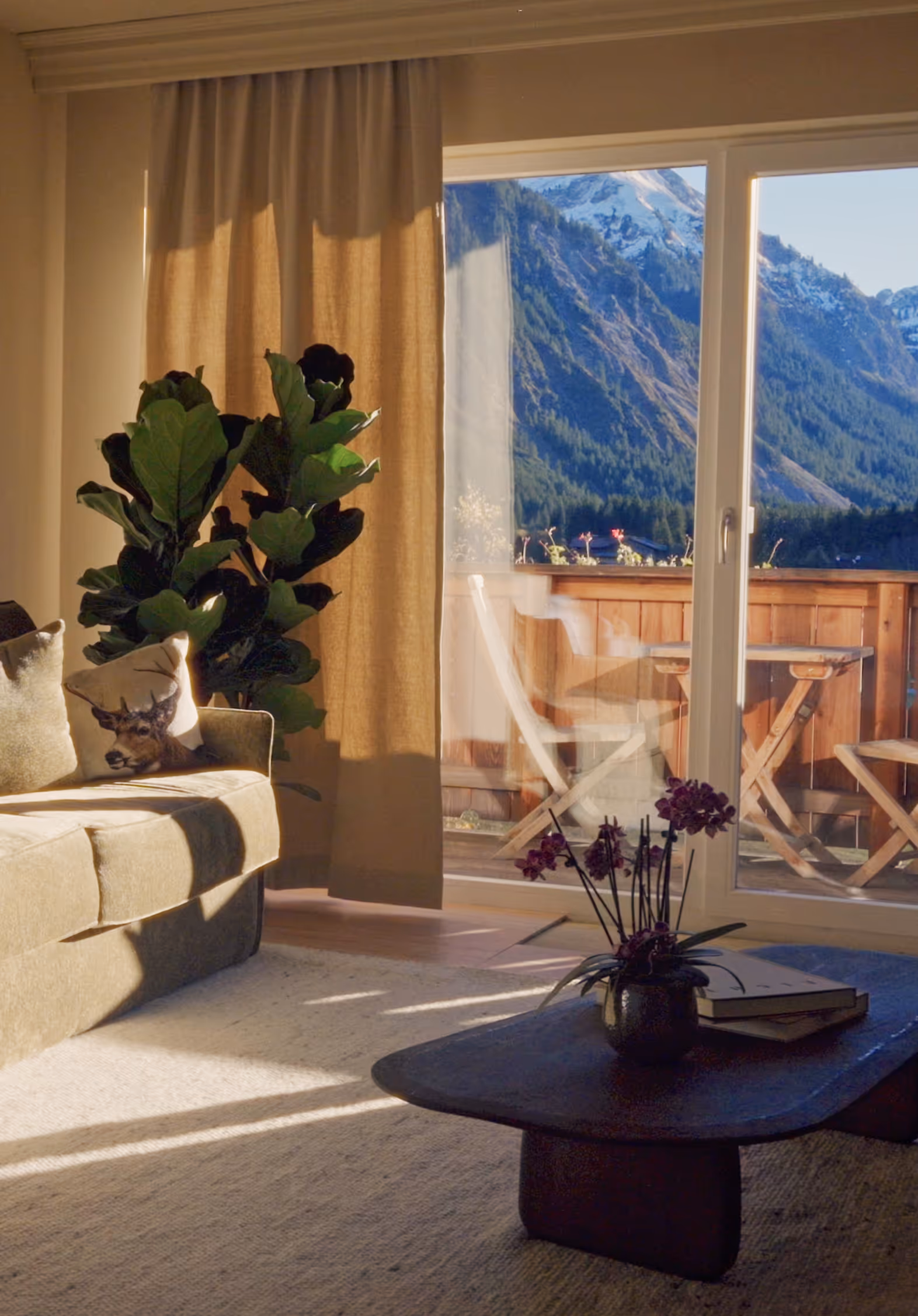 Heller Wohnbereich der Suite Vilsalpsee mit großem Fenster, Alpenblick und sanfter Nachmittagssonne.