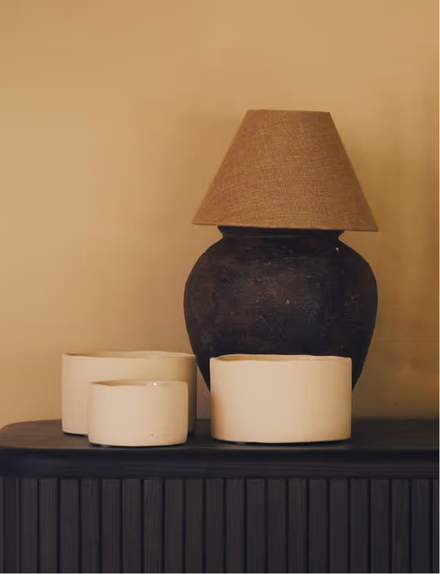 Stilvolle Details in der Suite Vilsalpsee – handgefertigte Keramikgefäße und Tischlampe auf dunkler Kommode.