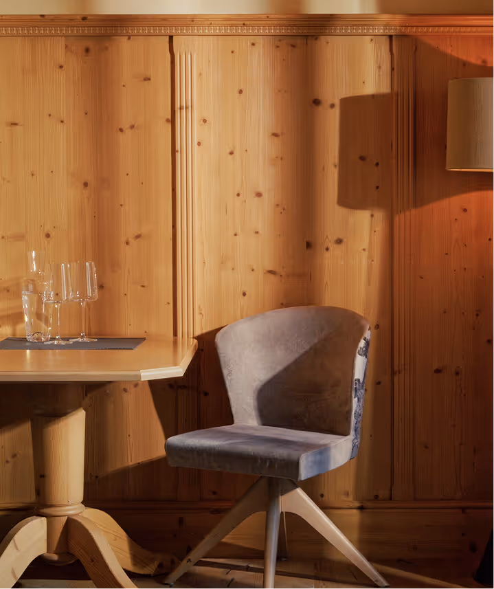 Einladende Sitzecke im Doppelzimmer Edelweiß – natürliche Materialien, dezente Beleuchtung und handwerkliche Details.