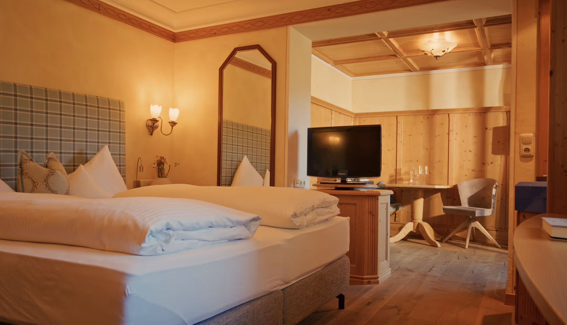 Gemütliches Doppelzimmer Edelweiß im Hotel Hohenfels mit hellen Holzelementen, Fernseher und traditioneller Einrichtung.