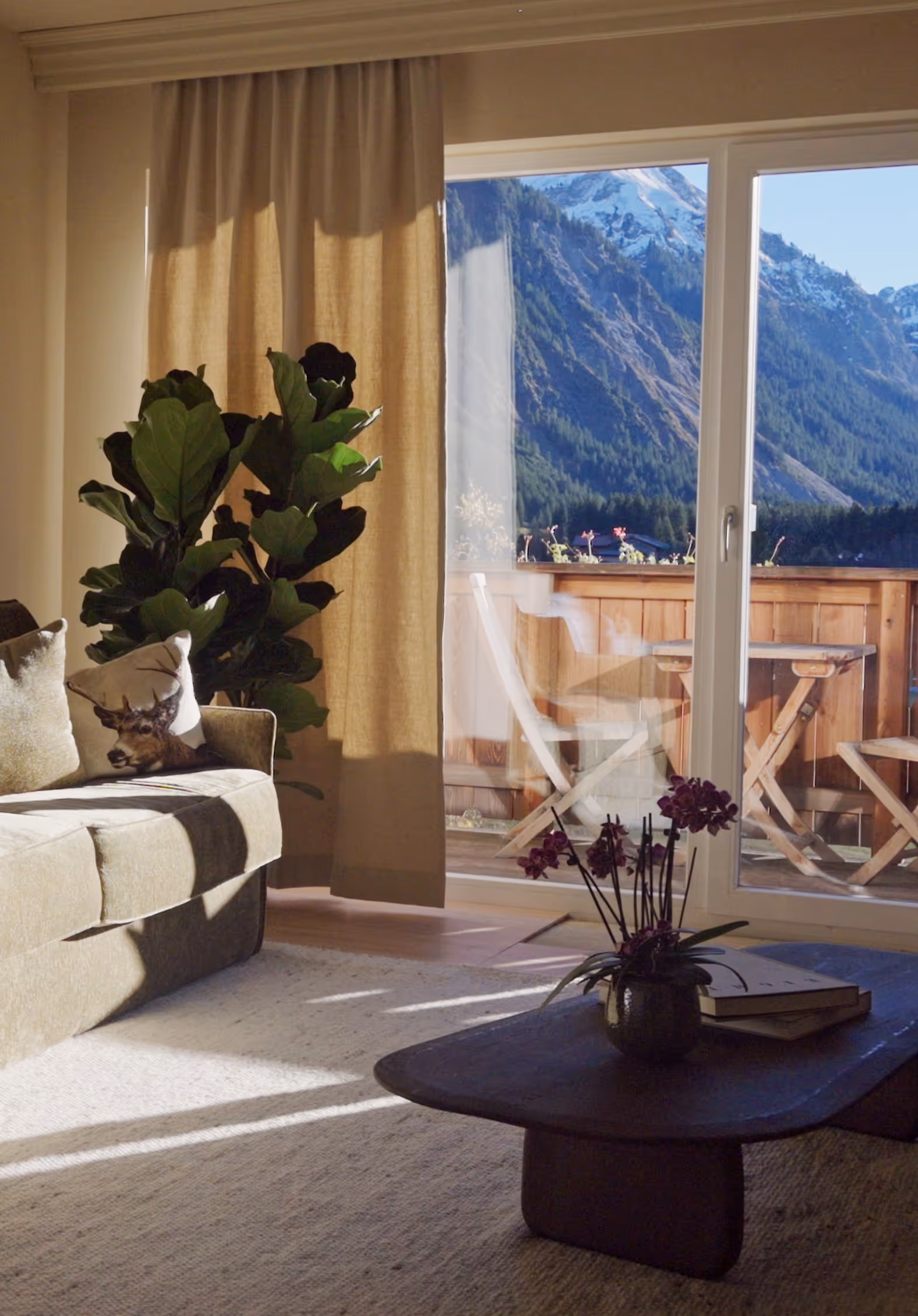 Heller Wohnbereich der Suite Vilsalpsee mit großem Fenster, Alpenblick und sanfter Nachmittagssonne.