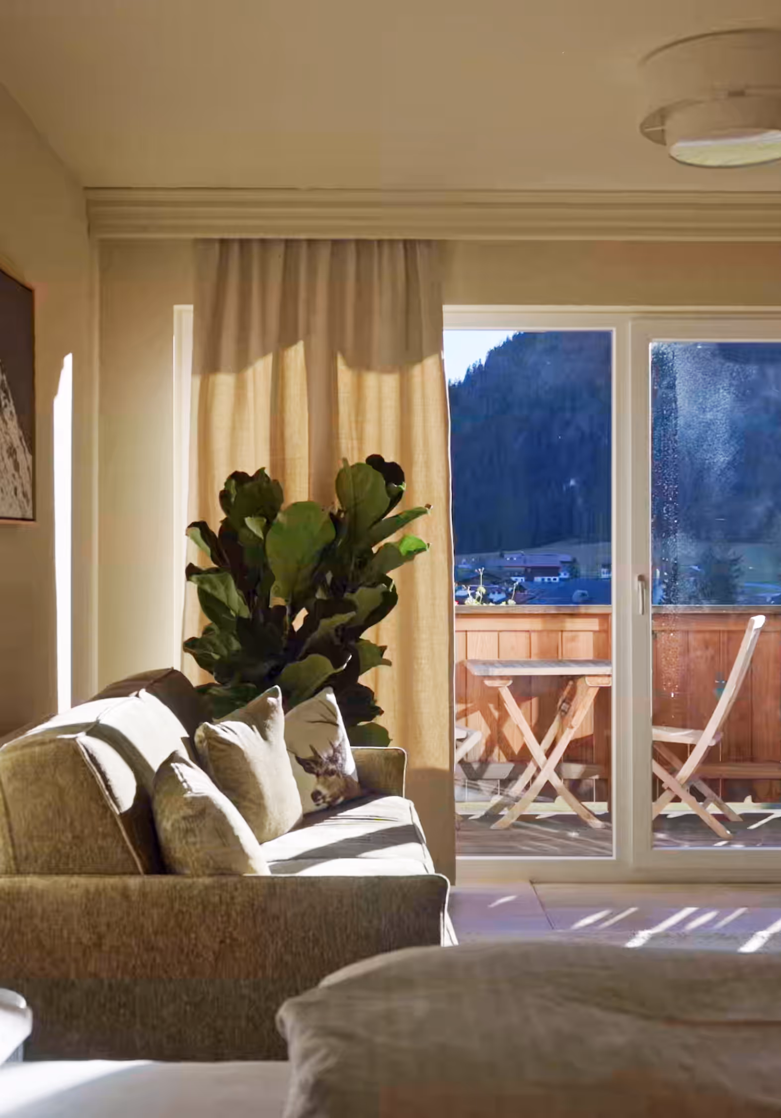 Heller Wohnbereich der Suite Vilsalpsee mit großem Fenster, Alpenblick und sanfter Nachmittagssonne.