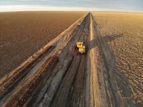 Heavy machinery working on cotton farm clearing roads