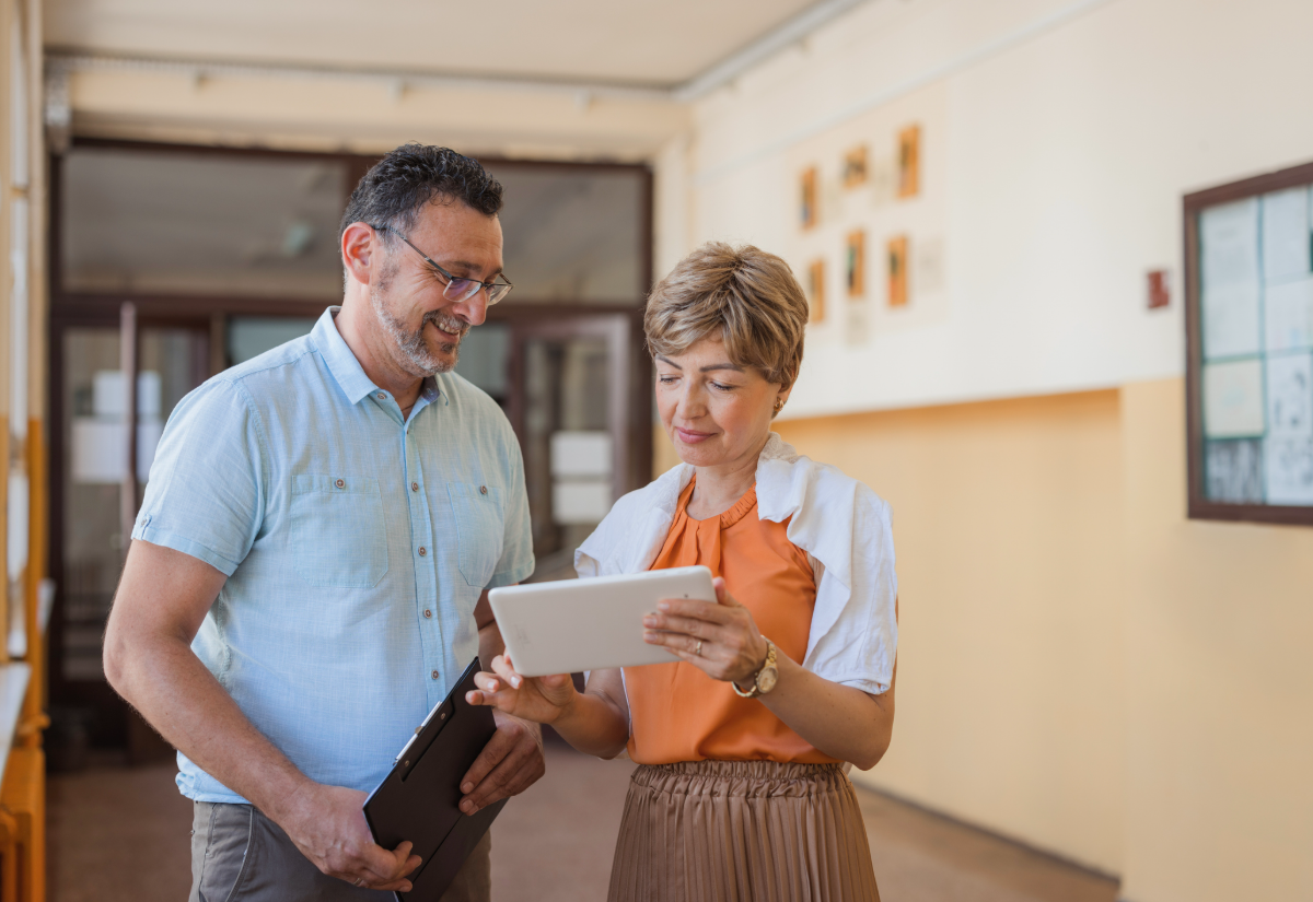 A school principal talking with a colleague in a school corridor