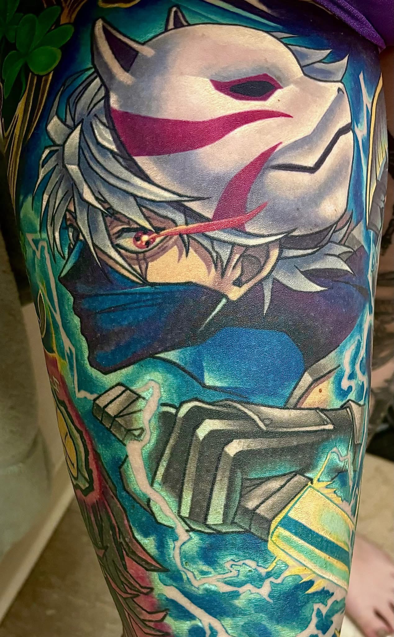 Colorful tattoo of an anime-style character with white hair.