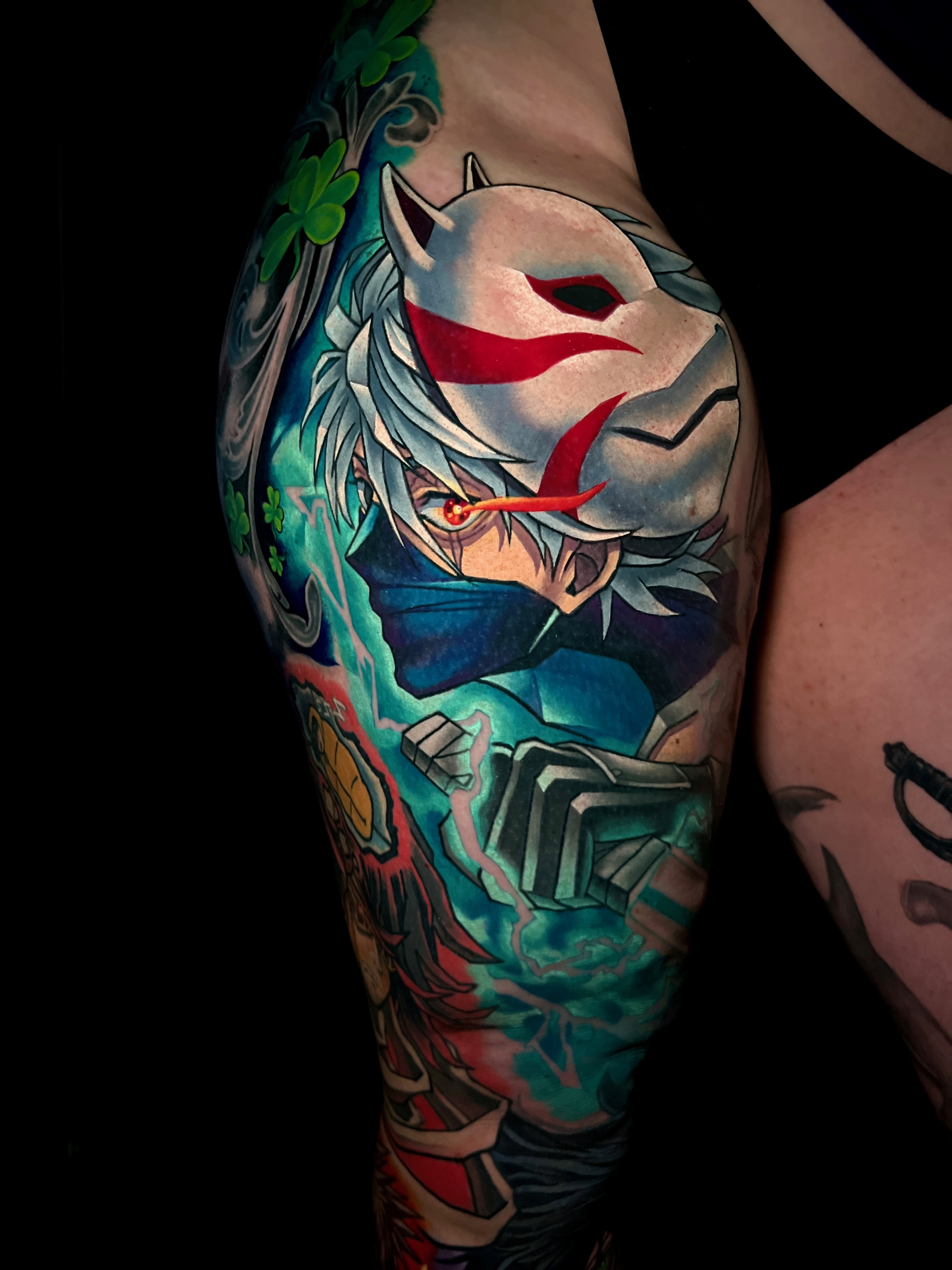 Colorful tattoo of an anime character with white hair, red eye, wearing a white fox mask.