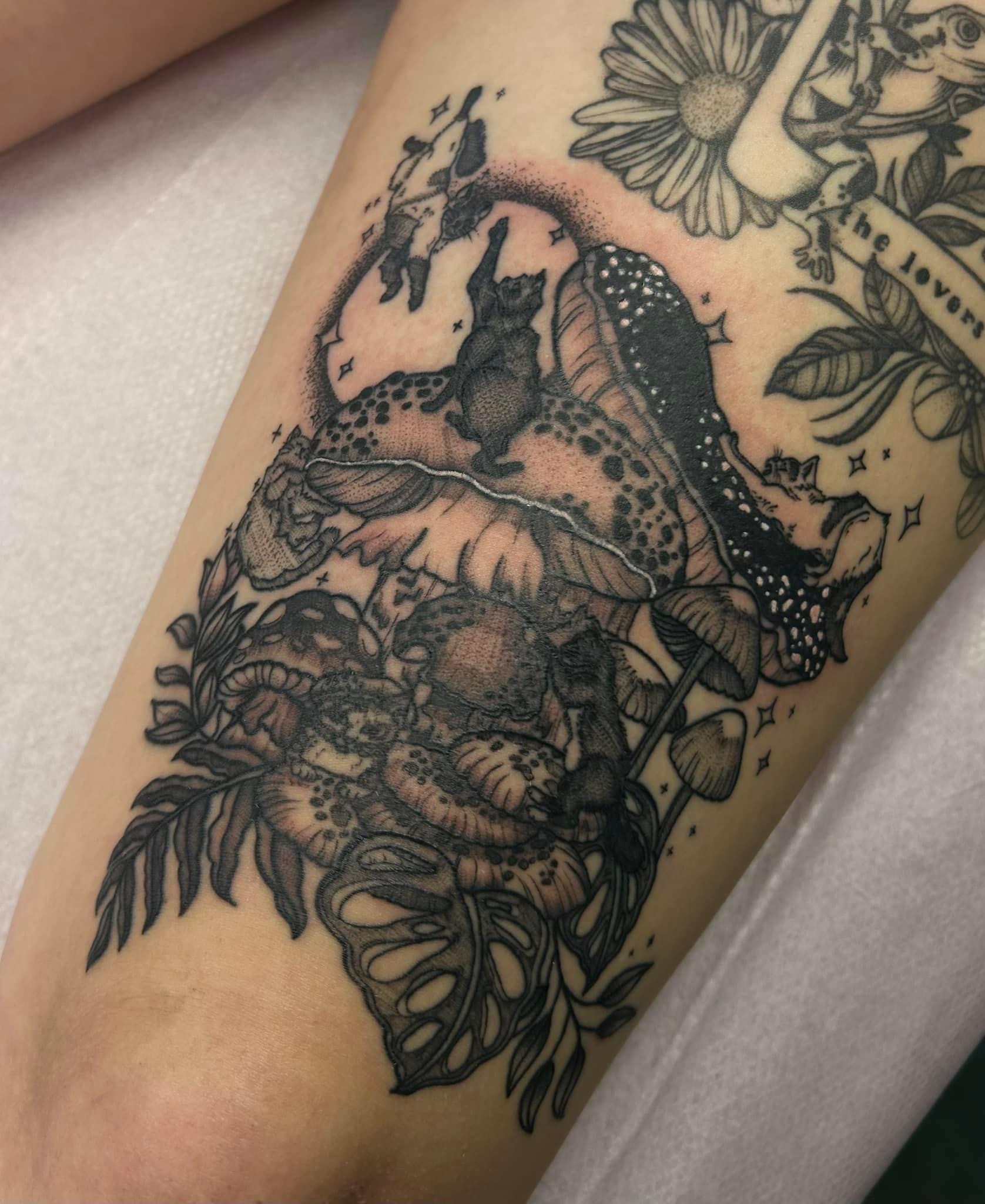 Fine line tattoo of small animals playing on and around the mushrooms with stars in the background.