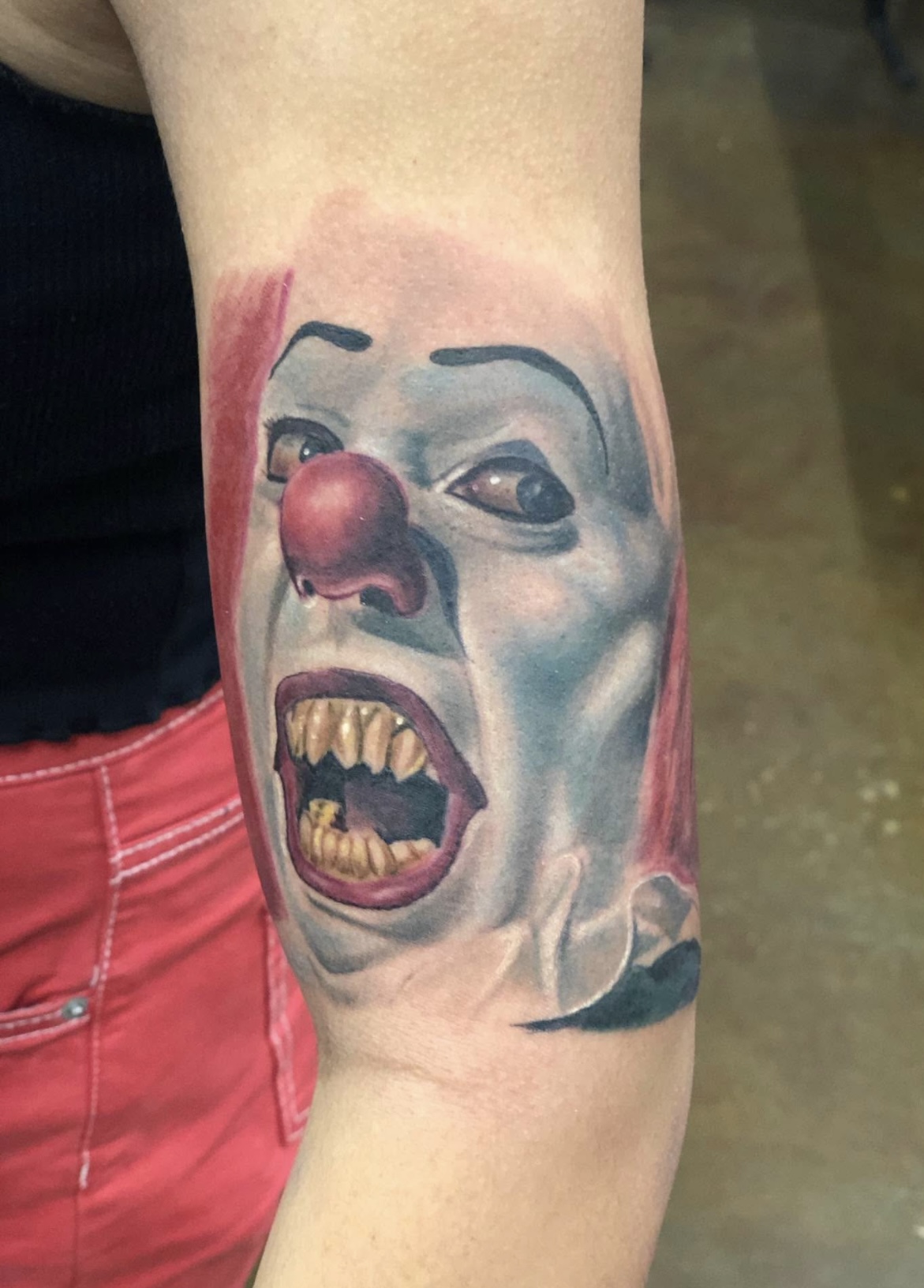 Color realism portrait tattoo of Pennywise the clown from the original It movie series.