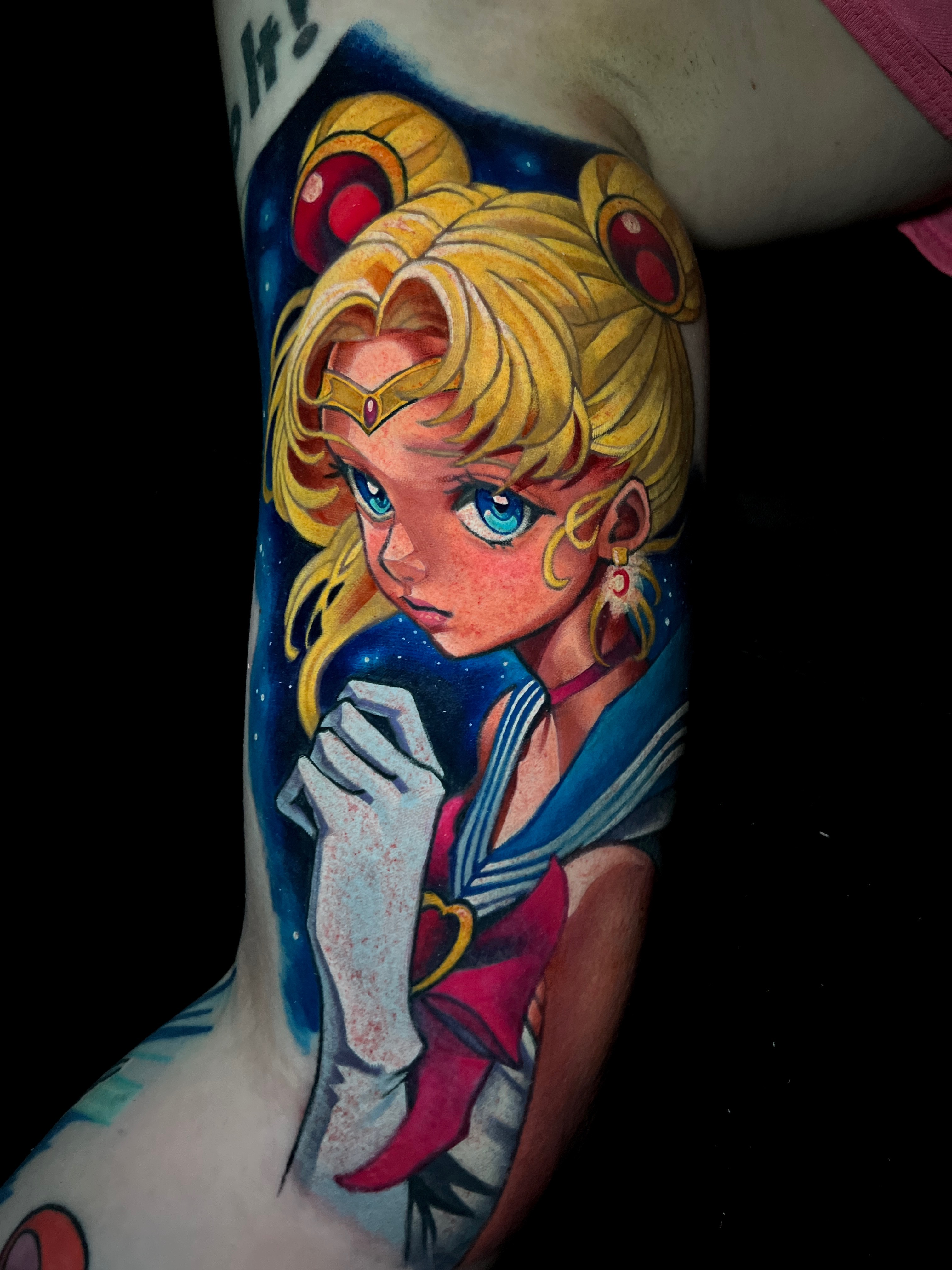 Tattoo of Sailor Moon against a starry background.