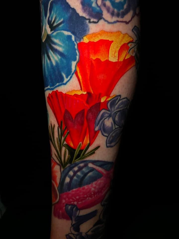 Colorful floral tattoo featuring vibrant red poppies