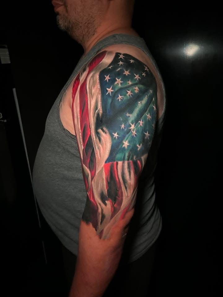 American flag with visible stars and stripes in red, white, and blue tattoo