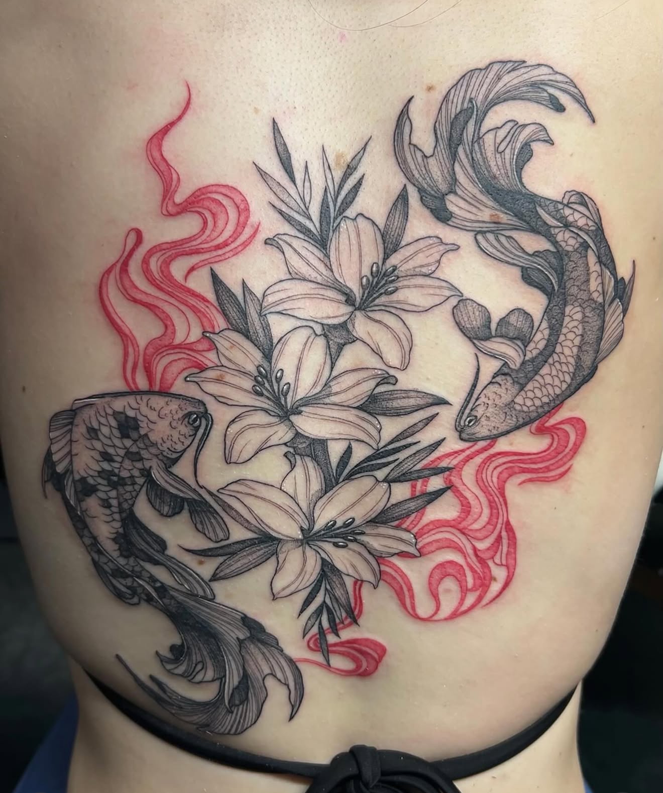 Fine line back tattoo of two koi fish