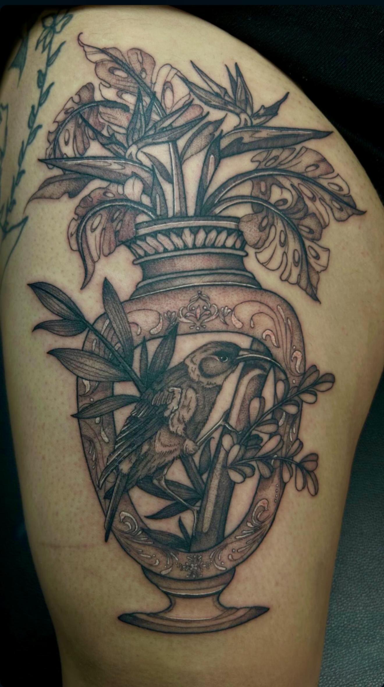 Tattoo of an ornate vase with detailed leaves, flowers, fine line