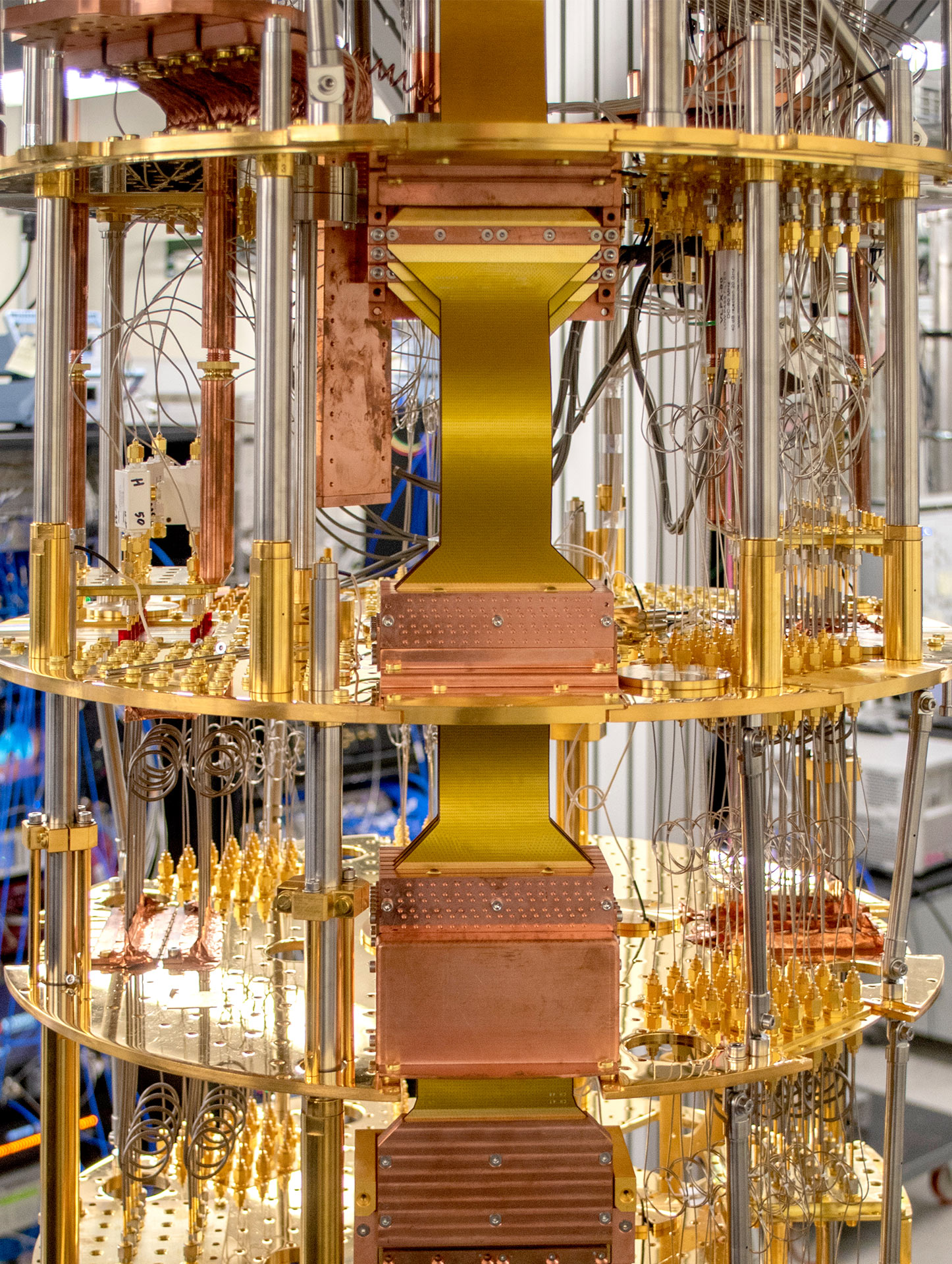 Close-up of a quantum computer's intricate cooling and wiring system with gold and copper components.