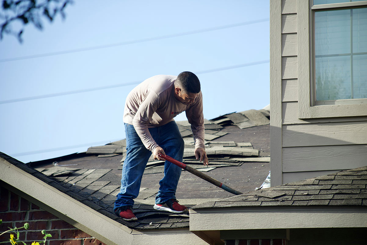 Older asphalt shingle roof showing wear before replacement