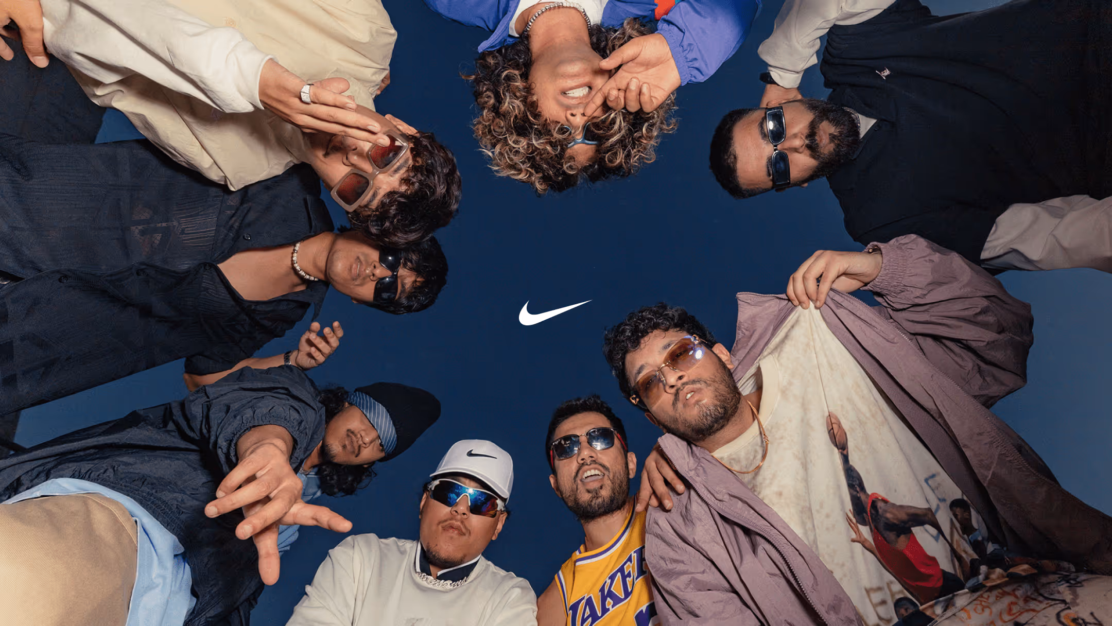 Trendy people in a circle looking down on a camera