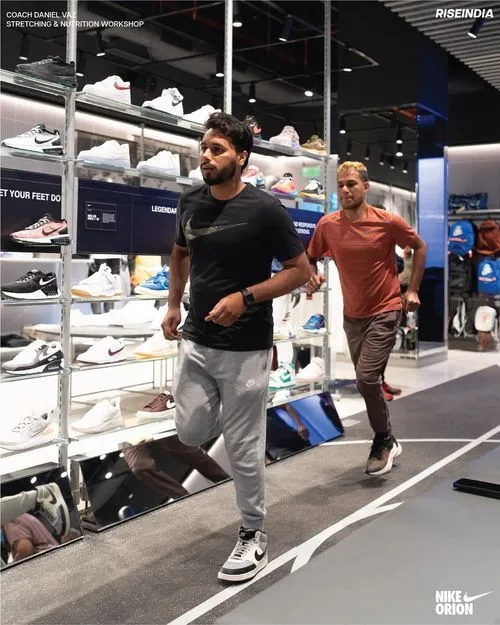 Two athletes running in a large nike store