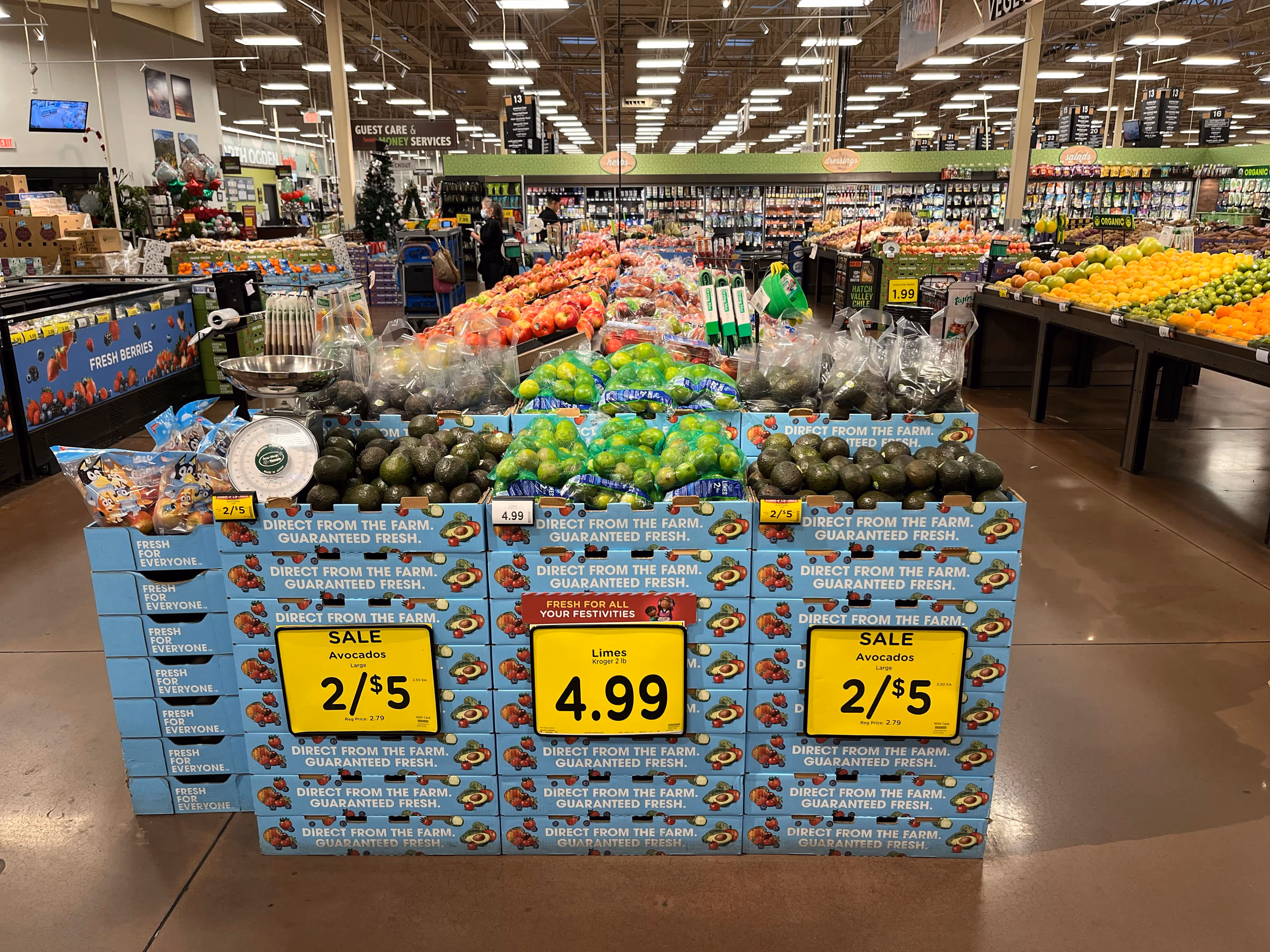 Grocery store shelf stocked with various packaged leafy greens including romaine, green leaf, and red leaf lettuce, with an organic produce sign.