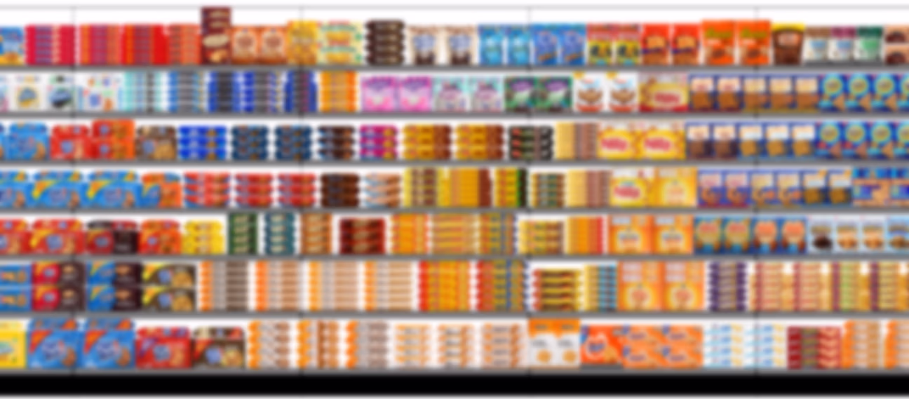 Shelf stocked with various packaged cookies and snack bars arranged in rows, including brands such as Famous Amos, Chips Ahoy, Keebler, and others.