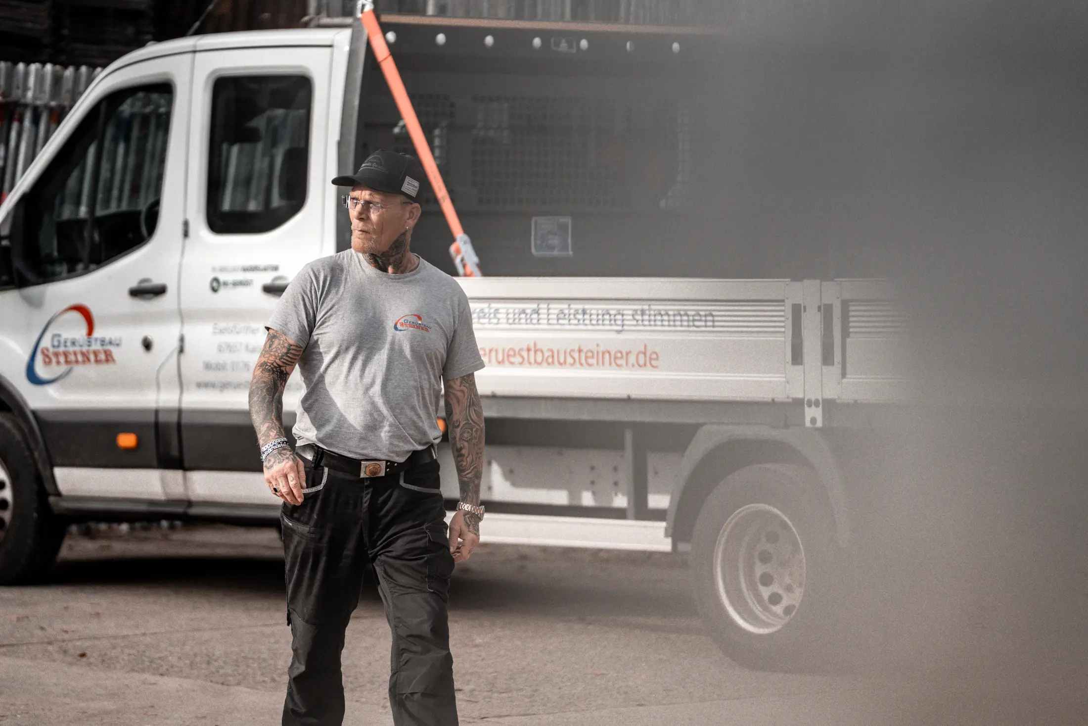 Geschäftsführer steht vor Fahrzeug