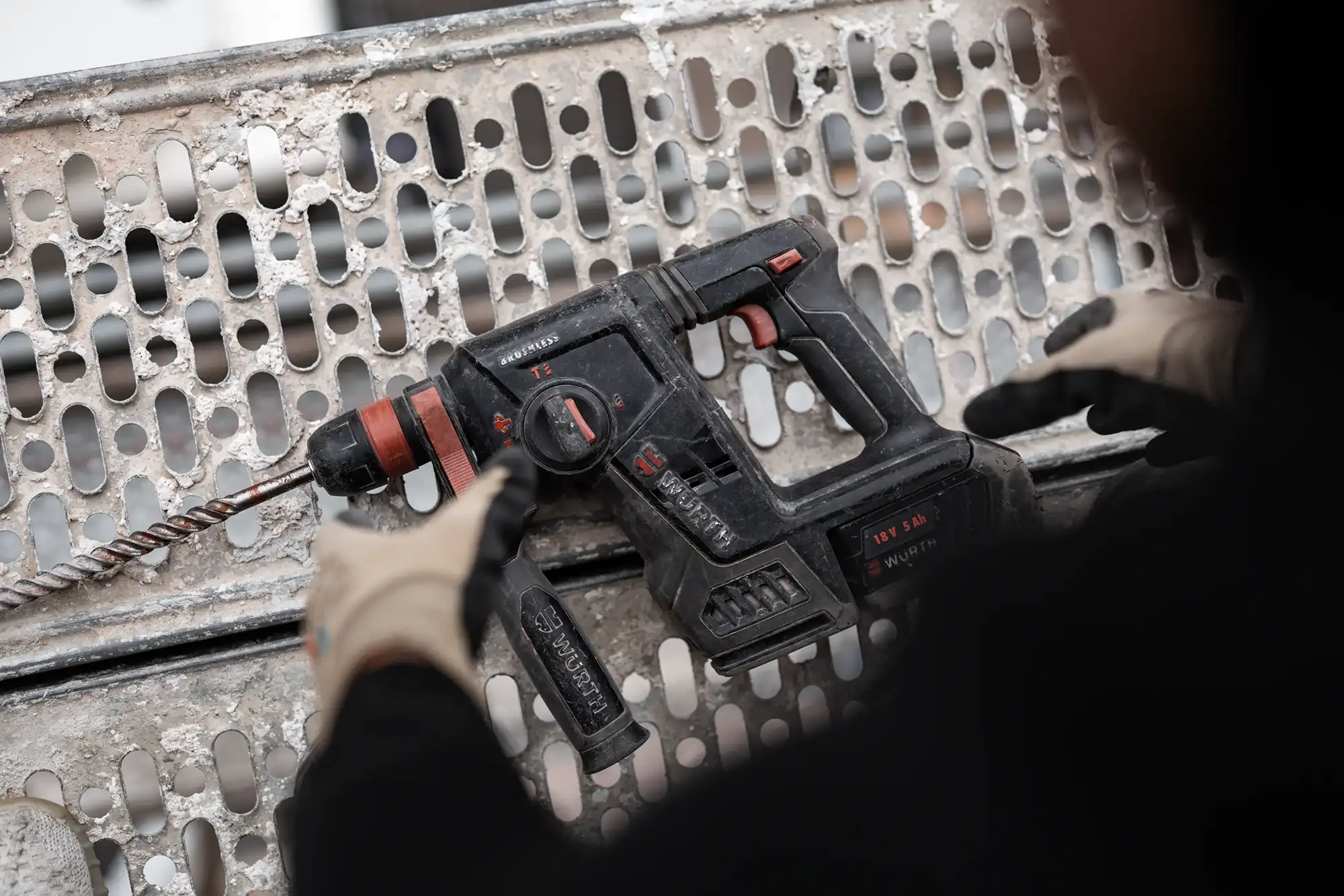 Arbeiter greift nach Bohrmaschine