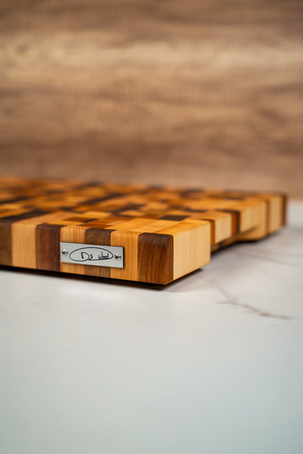 Planche à découper en bois bicolore avec un petit panneau métallique gravé "Ds Wood".