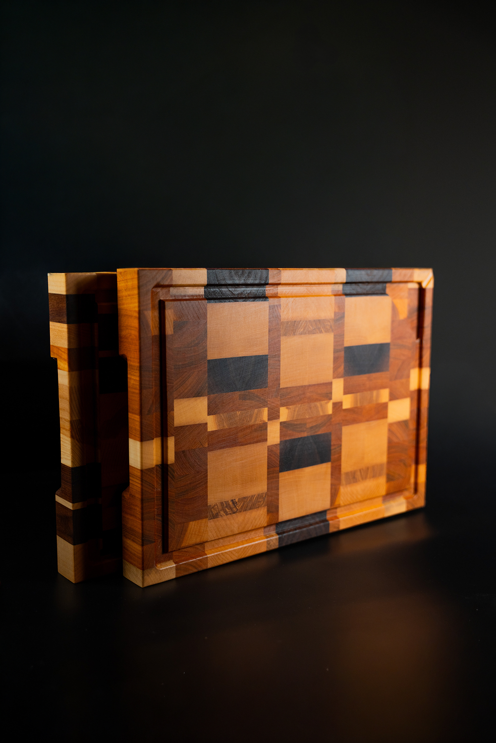 Deux planches à découper en bois à motifs géométriques carrés de différentes nuances.