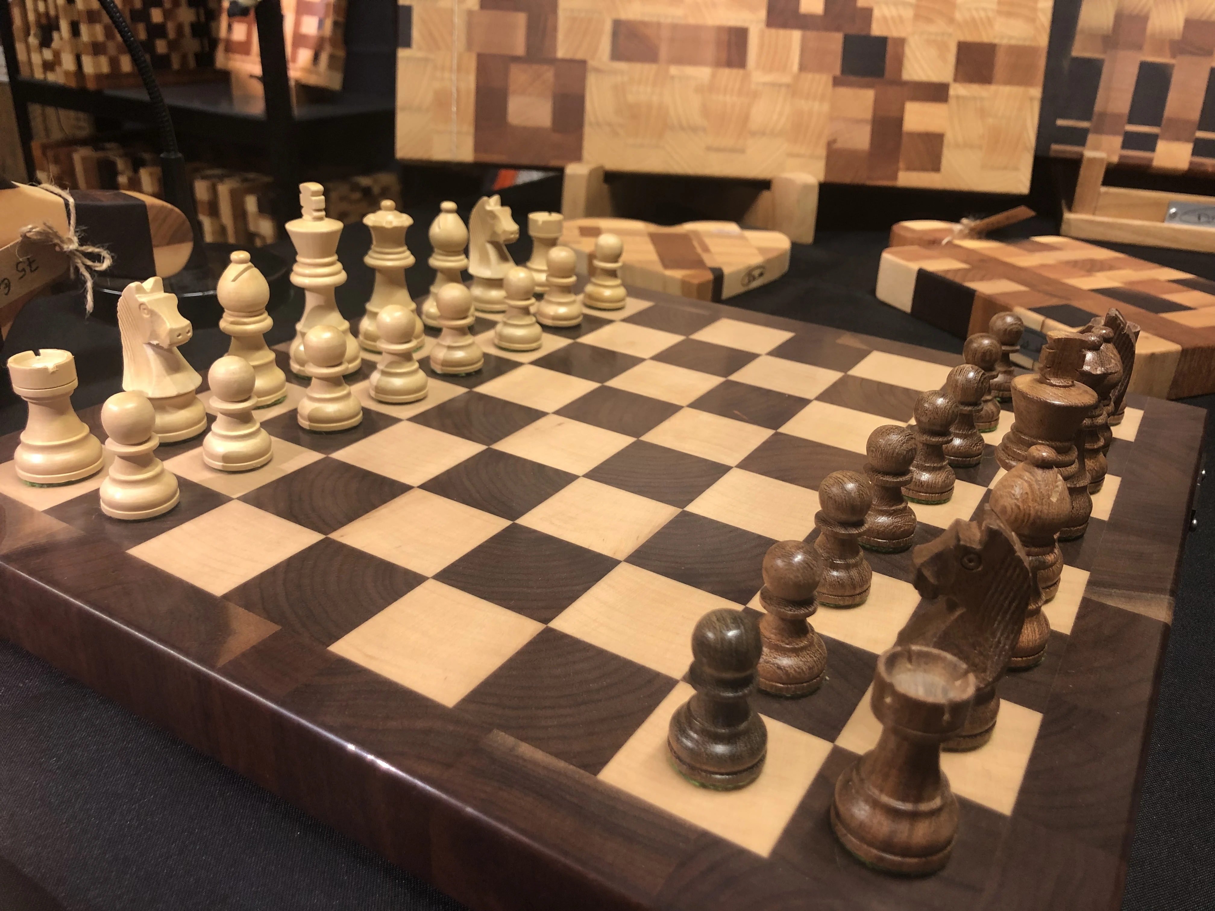 Un échiquier en bois avec pièces claires et foncées arrangées pour débuter une partie.