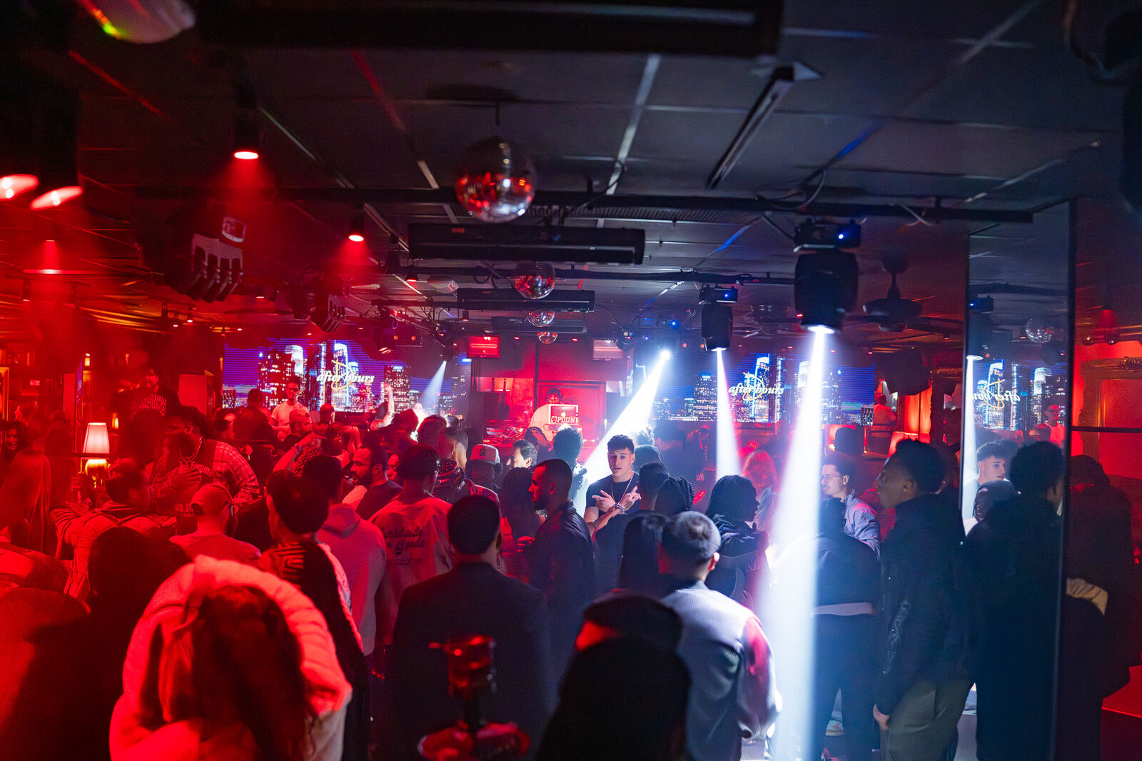 Light beams cut through red light over the crowd at Drai's After Hours