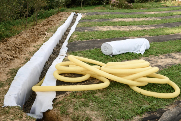 Дренажные трубы прокладывают с учётом требуемого диаметра, перфорации и класса жесткости, а также с обязательной обёрткой в геотекстиль.