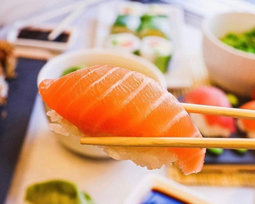 Positive young multiracial friends eating fast food and drinking beer in outdoor cafe