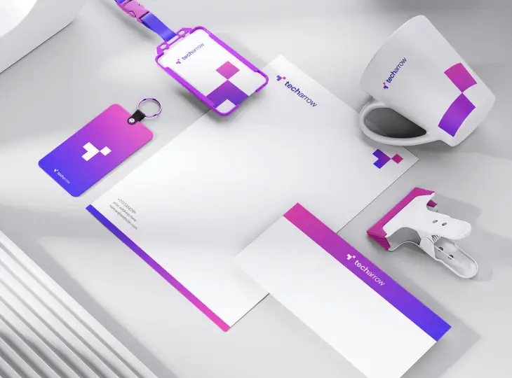 TechArrow branded stationery set including a lanyard badge, key card, letterhead, envelope, mug, and stapler on a white surface.