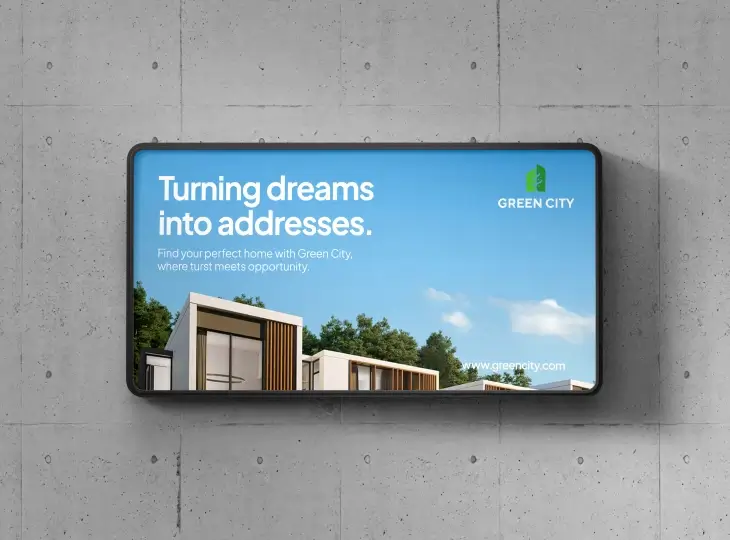 Billboard on concrete wall showing modern houses under blue sky with text 'Turning dreams into addresses' and Green City logo.