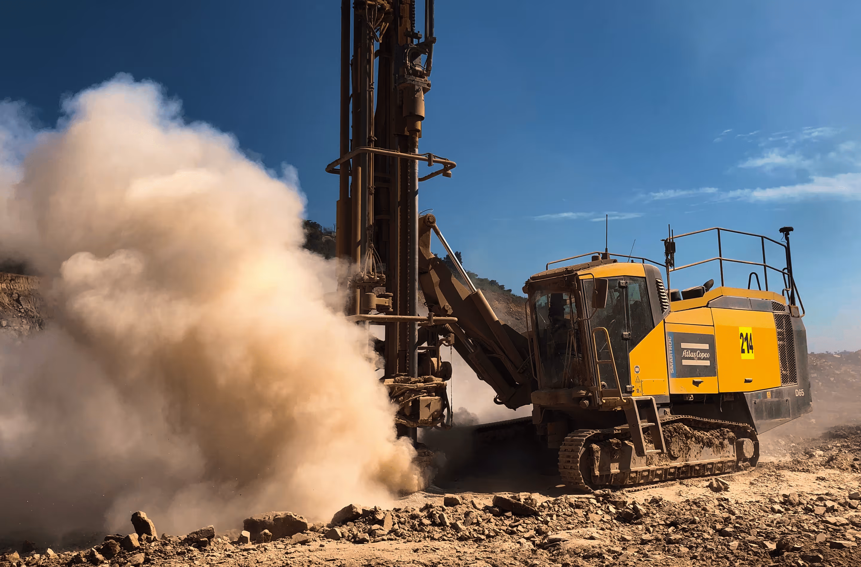 CAT drilling rig blasting operation - explosive dust cloud from rock drilling at quarry mining site"