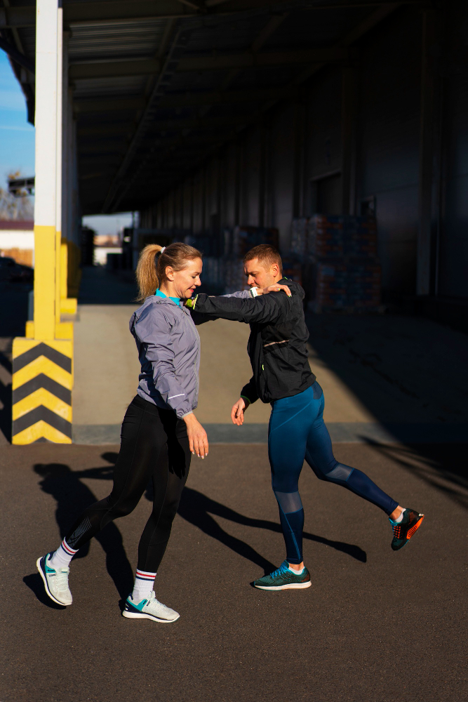 Athletic trainer working with baseball player on shoulder strengthening exercises for rotator cuff rehabilitation