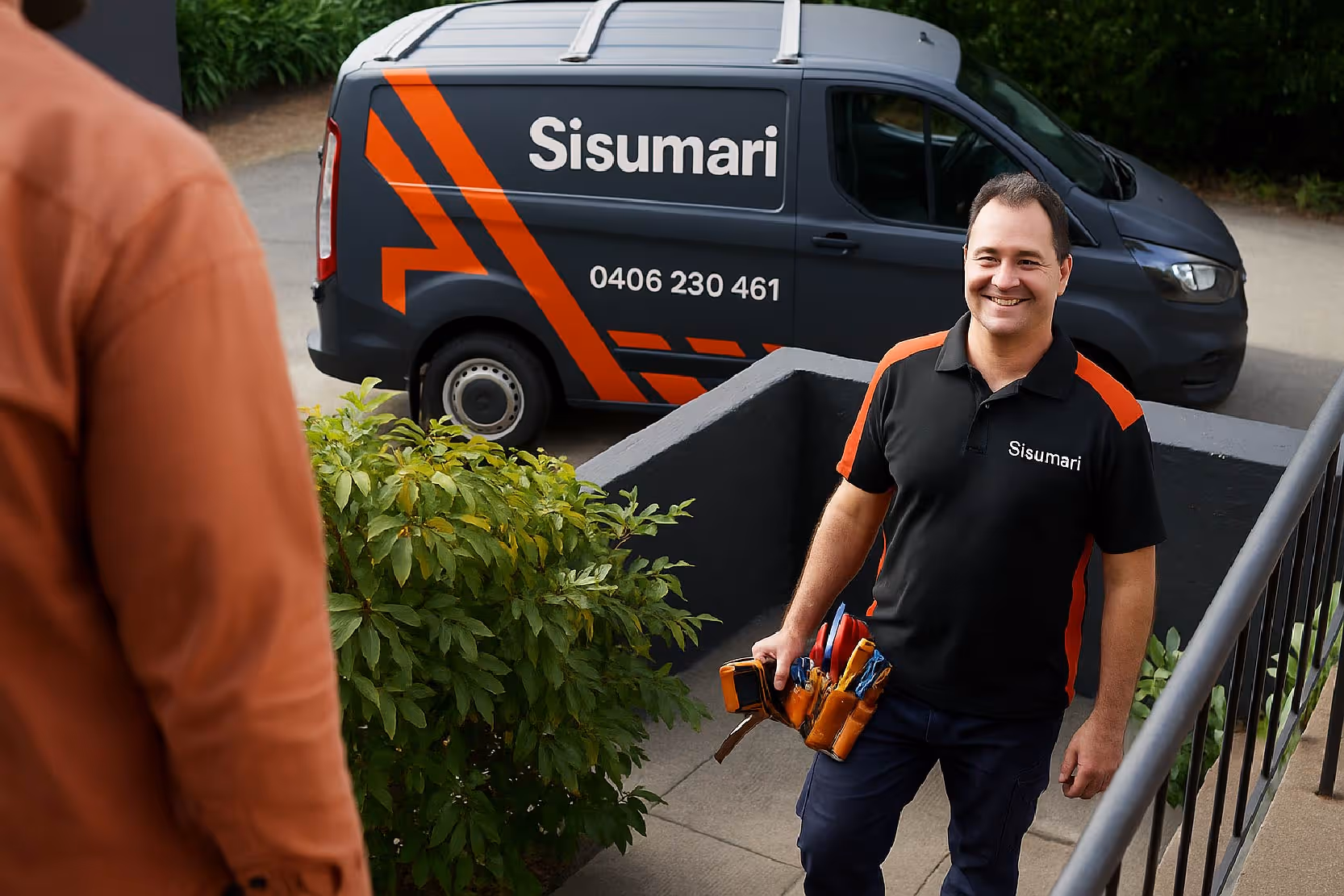 Smiling technician wearing a Sisumari uniform carrying tools, walking up stairs towards a delighted customer. Sisumari commercial wrapped medium van in the background