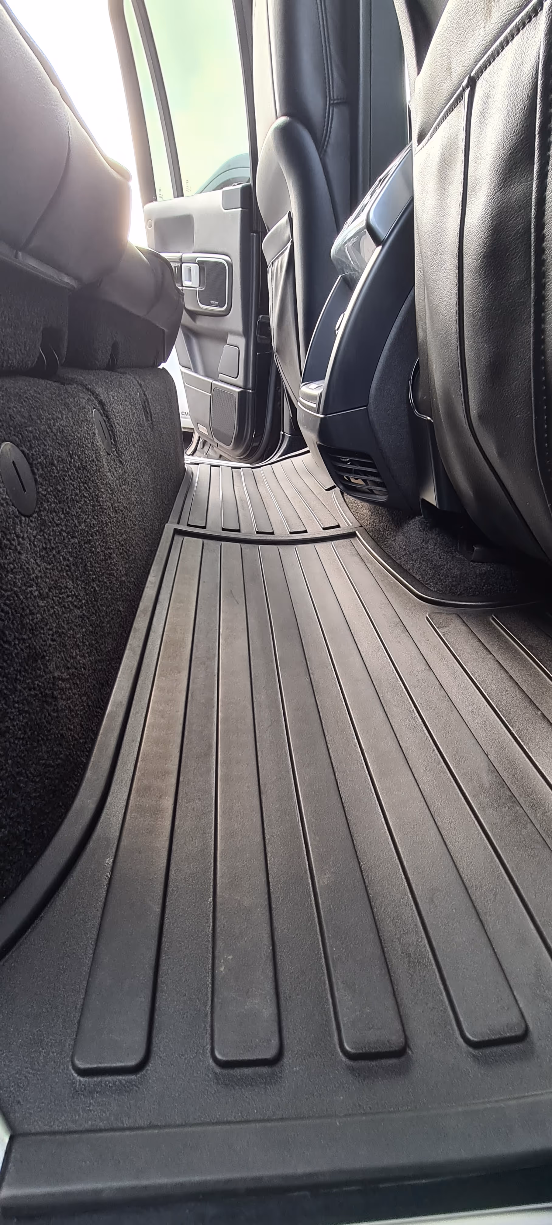 Rent gulv i bilens bagsædeområde med et sort gummi gulvtæppe