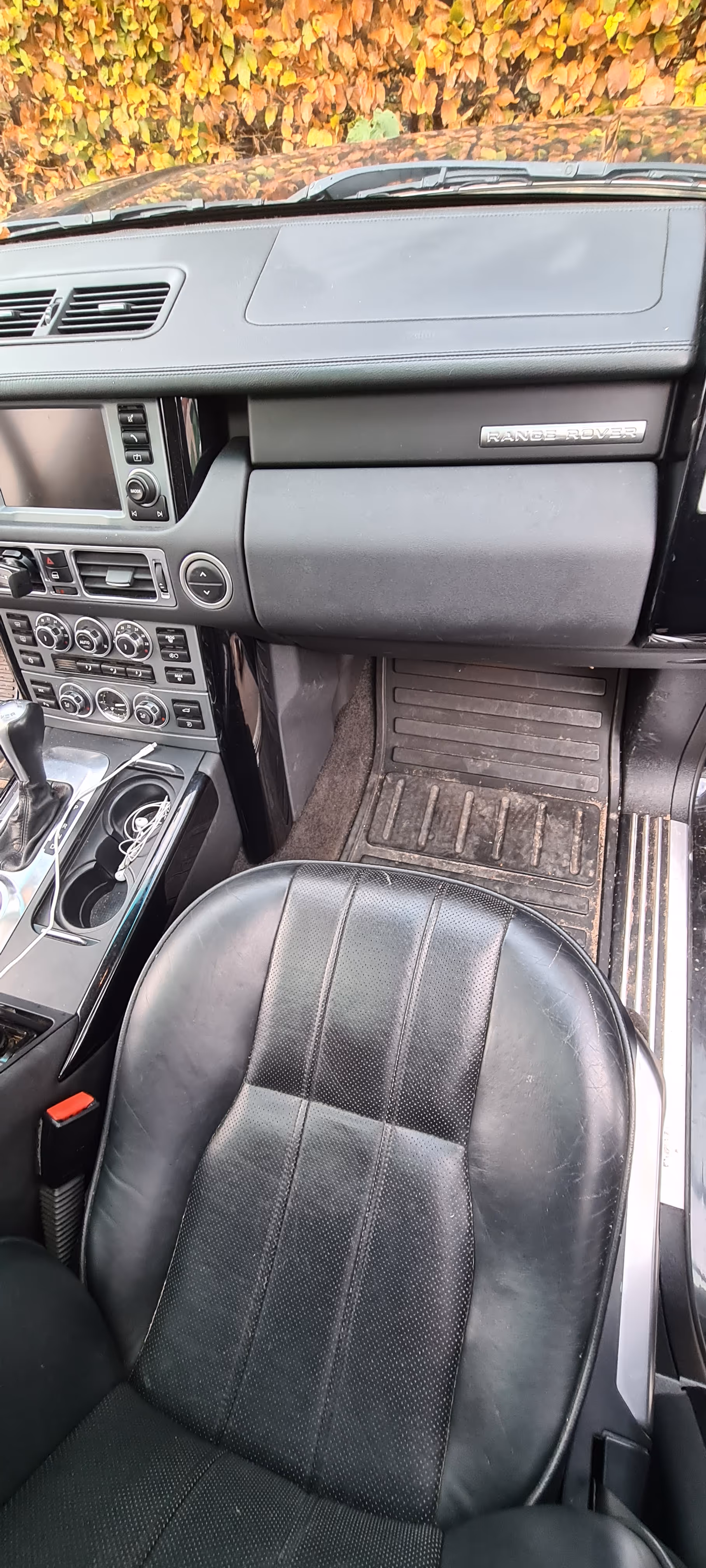 Nærbillede af det beskidte forsæde og instrumentbræt i indersiden af en Range Rover bil