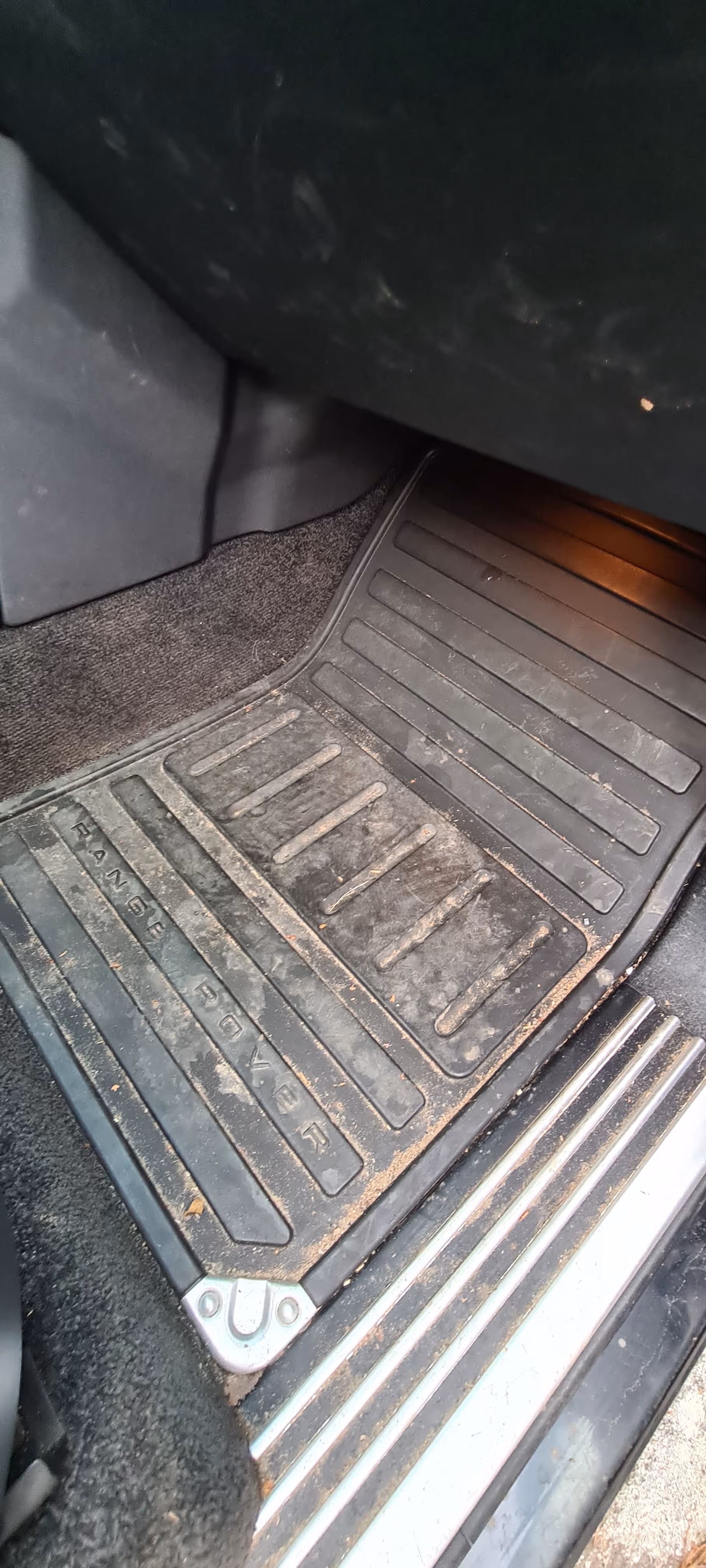 Beskidt sort Range Rover bil gulvtæppe med tekstureret gummi-overflade inde i køretøjet