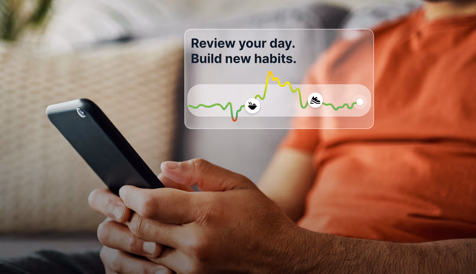 Person holding a smartphone with an overlay showing habit tracking graph and the text 'Review your day. Build new habits.'